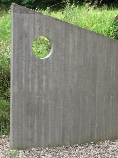 Sichtbetonwand mit rundem Ausschnitt als Gestaltungselement im Garten